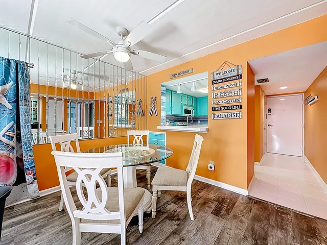 a dining room with furniture a chandelier and wooden floor