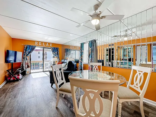 a living room with furniture a flat screen tv and a floor to ceiling window