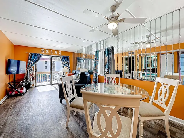 a living room with furniture a flat screen tv and a floor to ceiling window