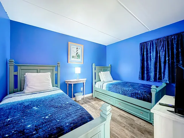 a bed sitting in a spacious bedroom next to a window