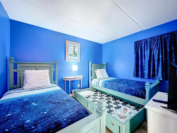 a bed sitting in a bedroom next to a window