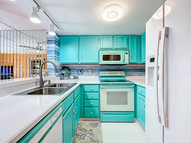 a kitchen with kitchen island a sink stove and refrigerator