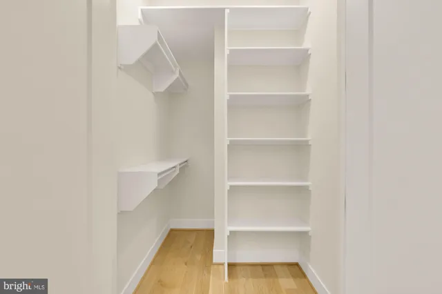 a view of walk in closet with empty racks