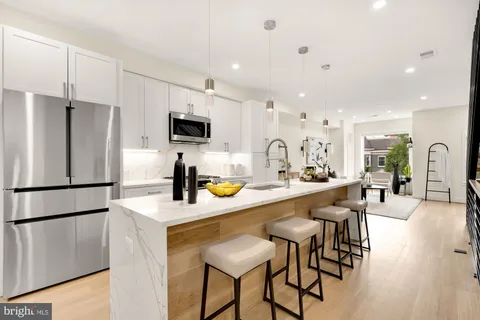a kitchen with stainless steel appliances granite countertop a refrigerator and a stove top oven