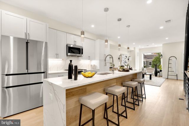 a kitchen with stainless steel appliances granite countertop a refrigerator and a stove top oven