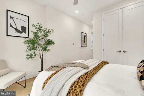 a bathroom with a toilet sink vanity granite and shower