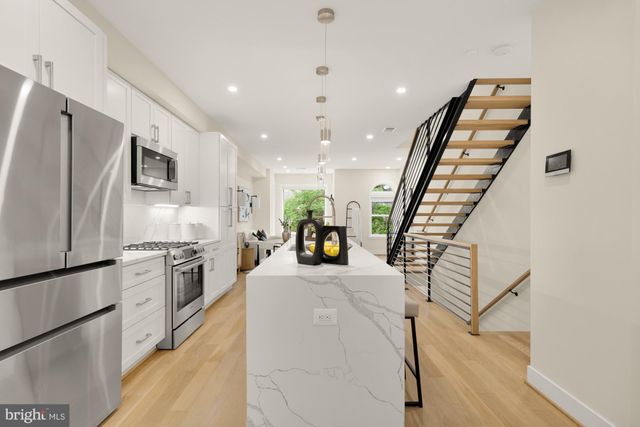 a kitchen with stainless steel appliances granite countertop refrigerator sink and stove