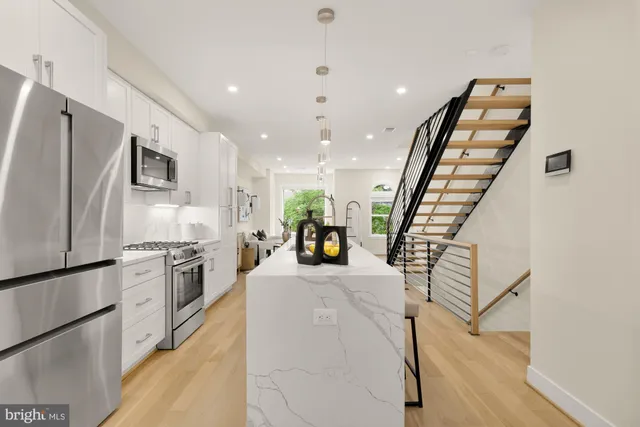 a kitchen with stainless steel appliances granite countertop refrigerator sink and stove