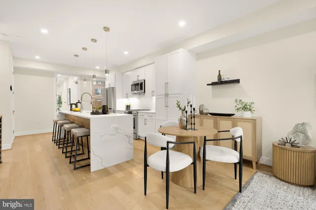 a kitchen with kitchen island a stove a table and chairs