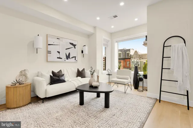 a living room with furniture and a painting on the wall