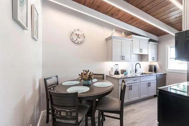a kitchen with a dining table chairs and white cabinets