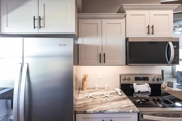 a kitchen with stainless steel appliances granite countertop a refrigerator and a stove top oven