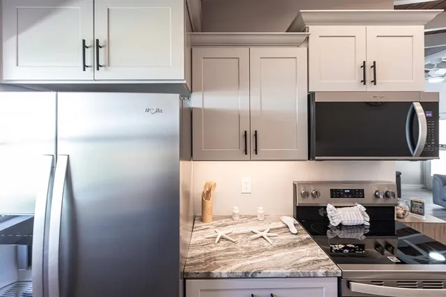 a kitchen with stainless steel appliances granite countertop a refrigerator and a stove top oven