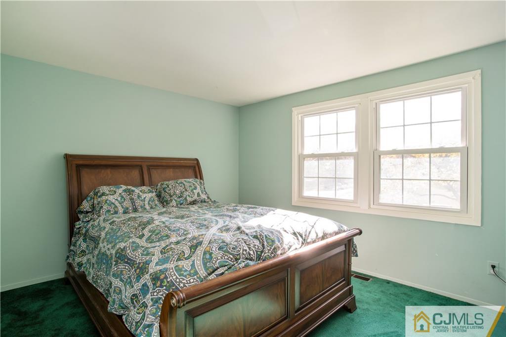 29 Abbott Road Somerset, NJ 08873 - Photo 8 of 10 a bed sitting in a bedroom next to a window