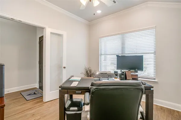 a view of a workspace with furniture and a window
