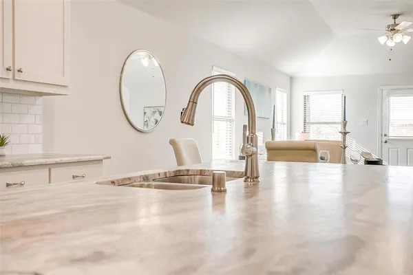 a view of empty room with kitchen view and wooden floor