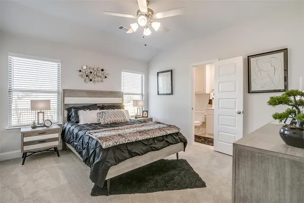a bedroom with a large bed and a chandelier