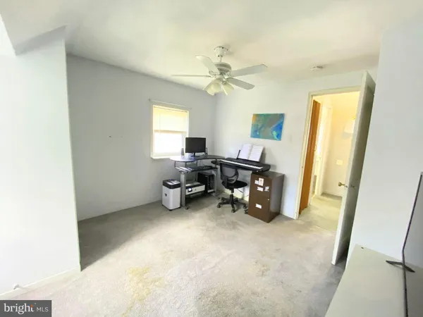 a view of a workspace with furniture and a window
