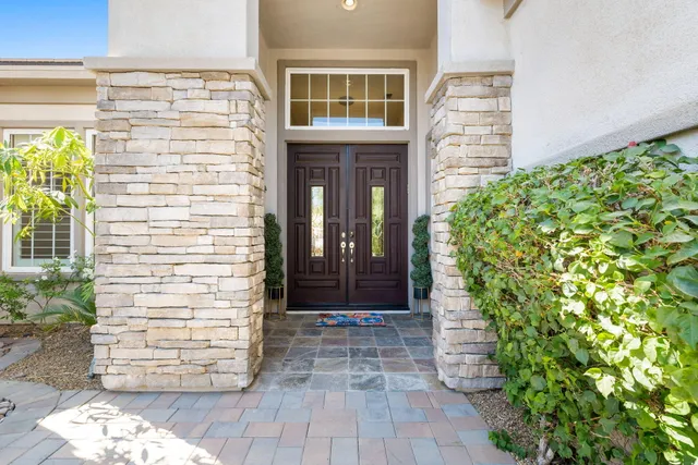 a dining hall with stainless steel appliances kitchen island granite countertop a dining table chairs and a living room view