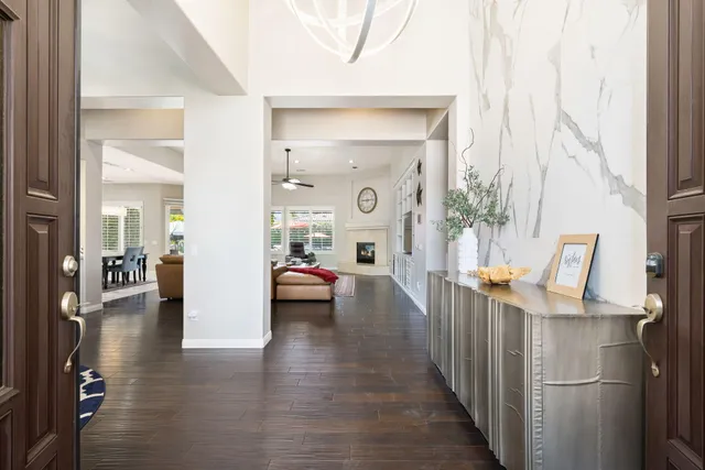 a kitchen with stainless steel appliances kitchen island granite countertop a sink a stove a dining table and chairs