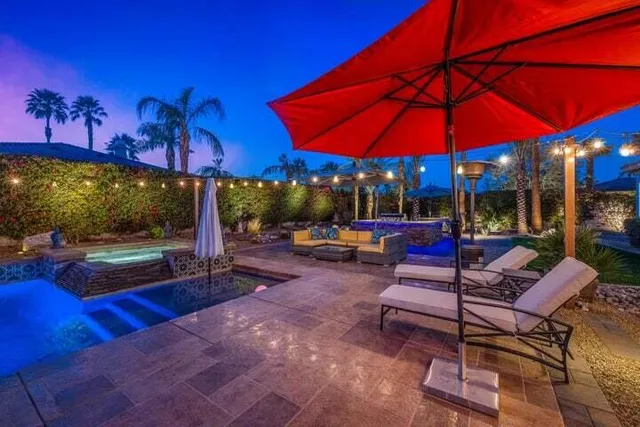 a view of a patio with a table and chairs under an umbrella