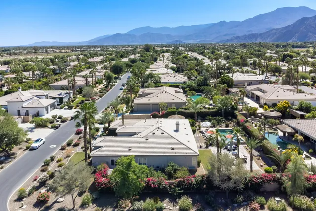 an aerial view of a house with a yard and large trees