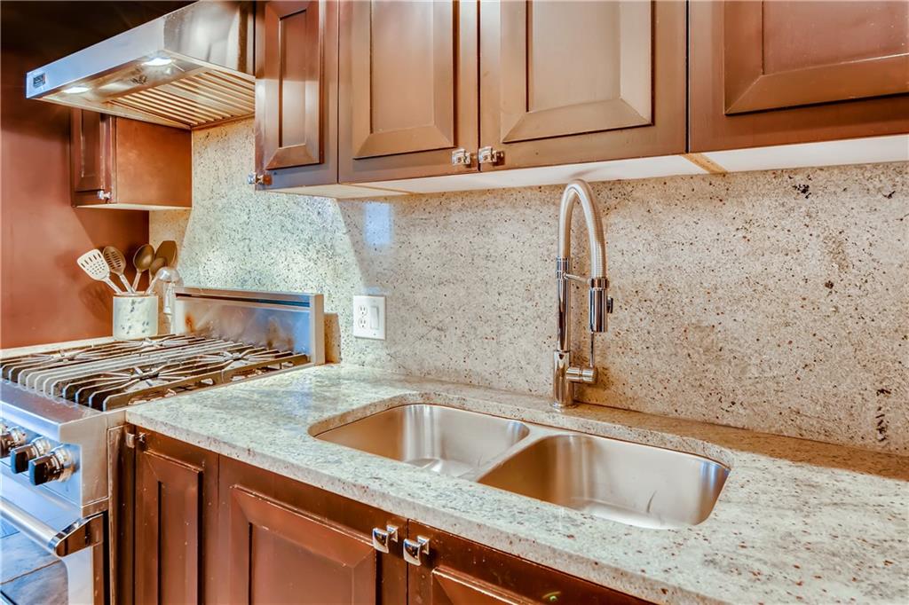 1820 Peachtree Road Northwest, Unit 811 Atlanta, GA 30309 - Photo 11 of 42 a kitchen with granite countertop a sink and a stove