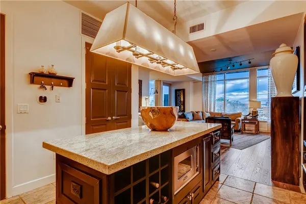 a kitchen with stainless steel appliances granite countertop a stove a sink and a dining table