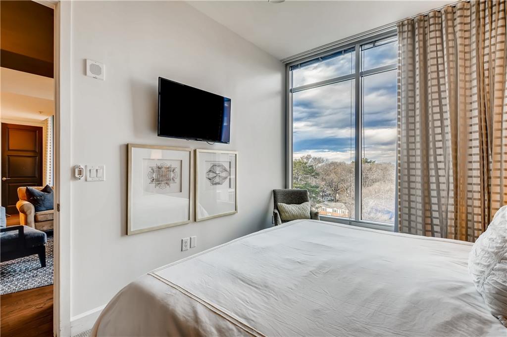 1820 Peachtree Road Northwest, Unit 811 Atlanta, GA 30309 - Photo 14 of 42 a bedroom with a bed and a flat screen tv