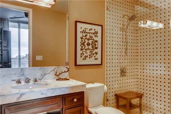 a bathroom with a granite countertop sink and a toilet