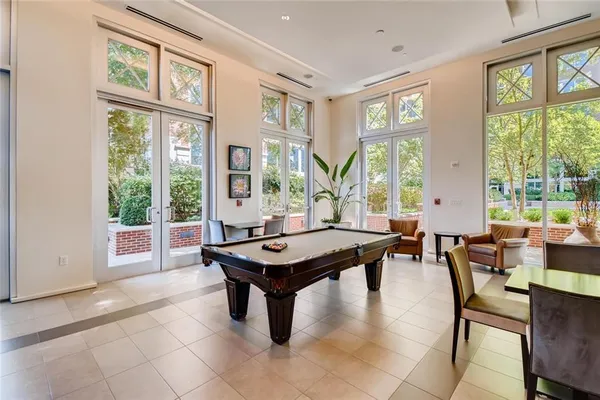 a dining room with furniture and large windows