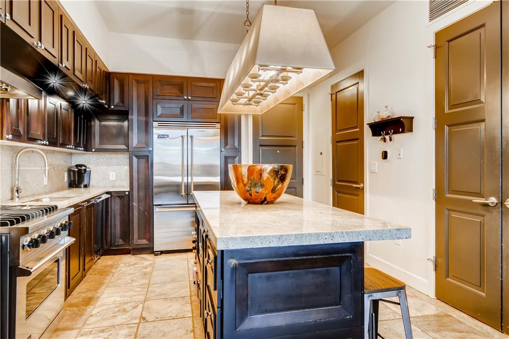 1820 Peachtree Road Northwest, Unit 811 Atlanta, GA 30309 - Photo 8 of 42 a kitchen with stainless steel appliances granite countertop a stove a refrigerator and a wooden cabinets
