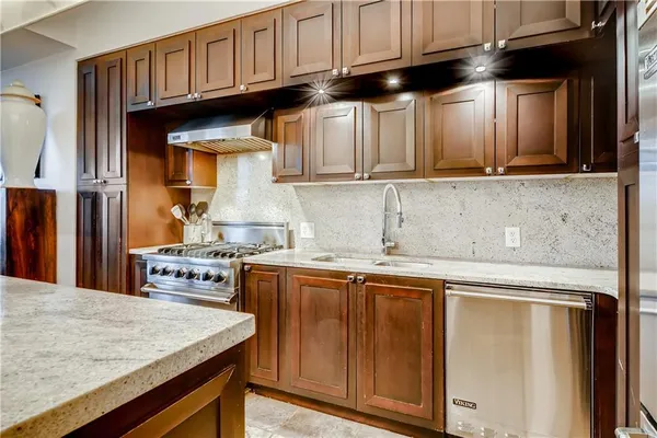 a kitchen with stainless steel appliances granite countertop a sink stove and refrigerator