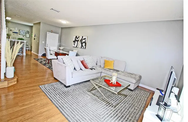a living room with furniture and a wooden floor
