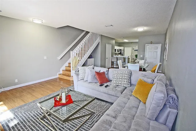 a living room with furniture and wooden floor