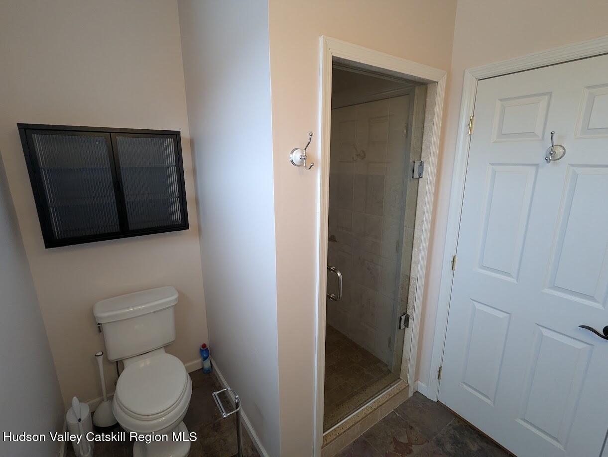 5359 Main Street, Unit 2H Windham, NY 12496 - Photo 11 of 22 a white toilet sitting next to a bathroom sink