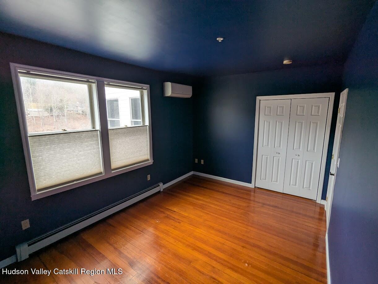 5359 Main Street, Unit 2H Windham, NY 12496 - Photo 12 of 22 an empty room with wooden floor and windows