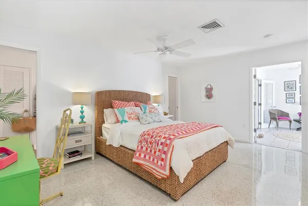 a bedroom with a bed and a lamp on the dresser