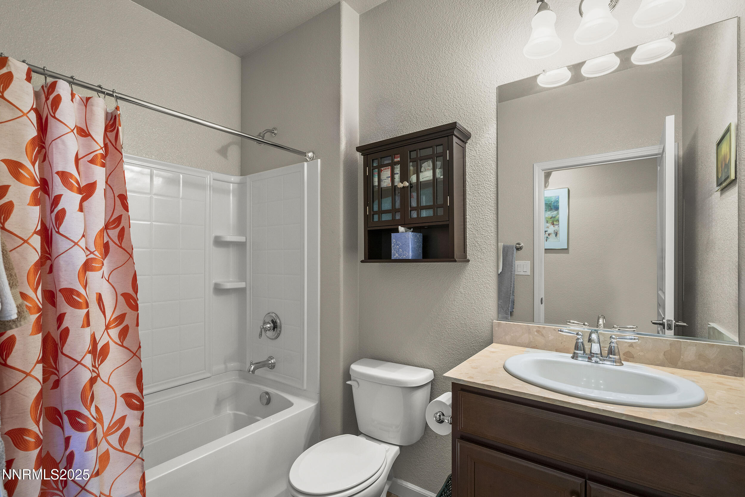 9165 Kenton Trail Reno, NV 89523 - Photo 20 of 22 a bathroom with a sink toilet a mirror and shower