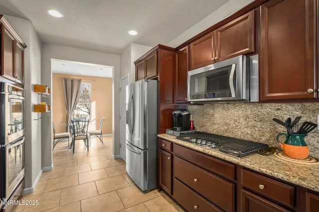 a kitchen with granite countertop a refrigerator and a stove top oven