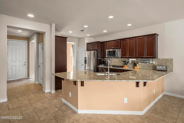 a view of a kitchen with stainless steel appliances granite countertop a stove and a refrigerator
