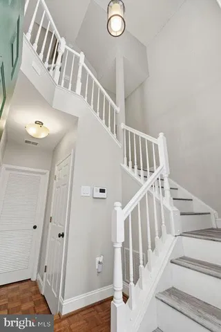 a view of staircase with lots of frames on wall and a window
