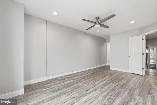 an empty room with wooden floor a ceiling fan and closet