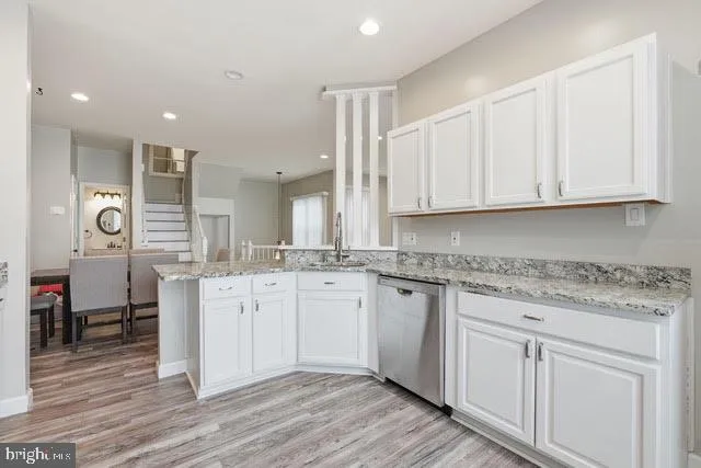 a kitchen with white cabinets appliances and a sink