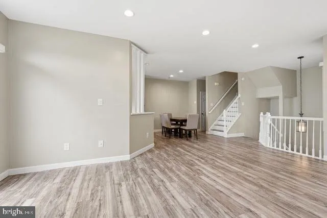 an empty room with wooden floor and furniture