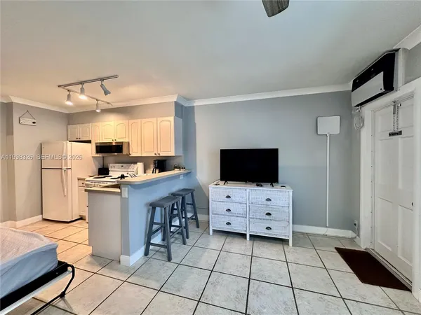 a room with a flat screen tv and a dresser