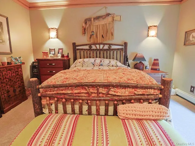 a bedroom with a bed and dresser with mirror
