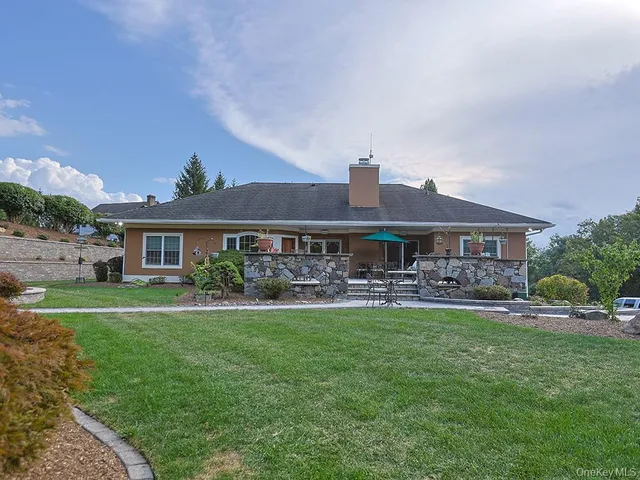 a front view of a house with garden and trees