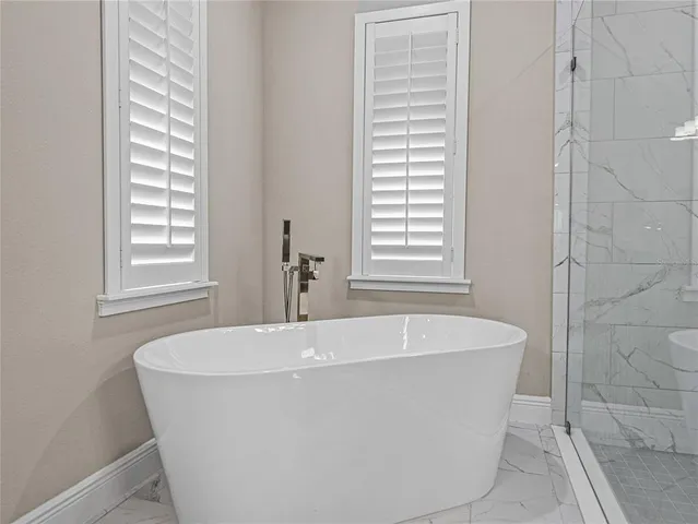 an aerial view of a residential houses with outdoor space and trees