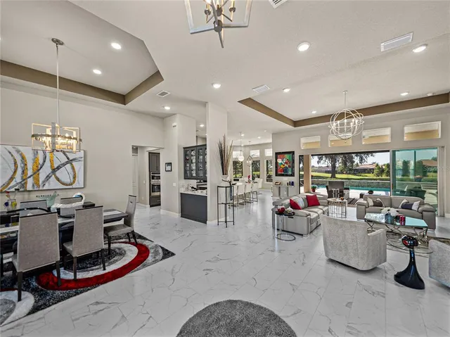 a living room with furniture kitchen view and a chandelier